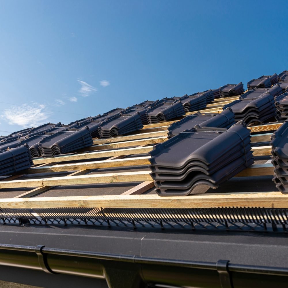 Roof ceramic tile arranged in packets on the roof on roof battens. Preparation for laying roof tiles